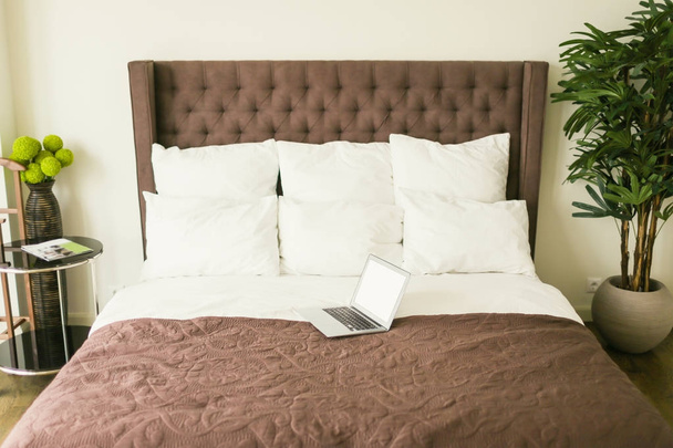 Laptop on bed with pillows - Фото, изображение