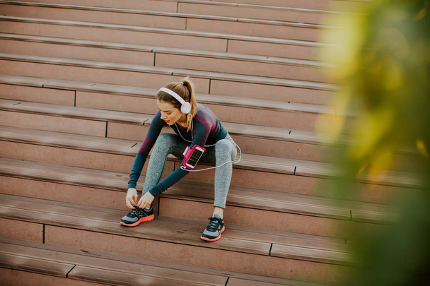 Attractive female runner taking break after jogging - Foto, imagen