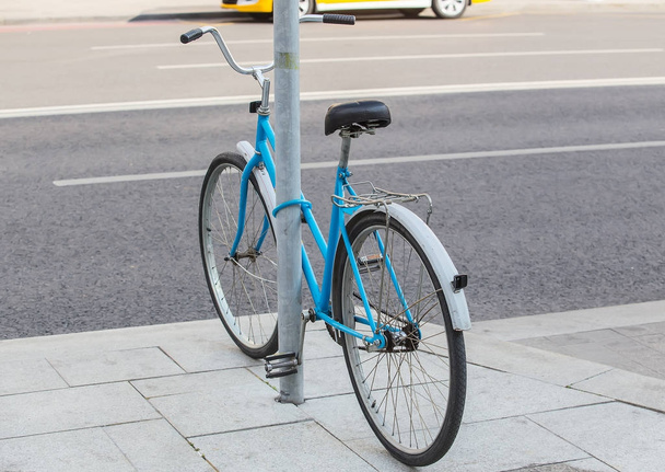 bicycle parked and fastened to pole - Zdjęcie, obraz