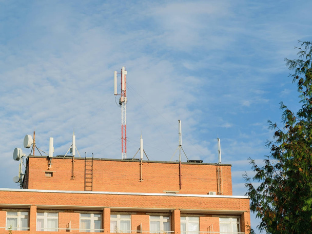 Антенны, установленные на крыше жилого кирпичного дома
. - Фото, изображение
