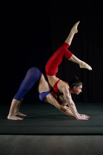 Дві дівчини займаються акробатикою в спортивній студії
  - Фото, зображення