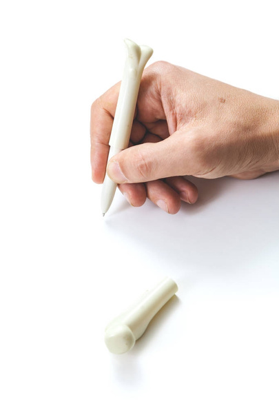 hand writing pen in bone shape on white background - Fotoğraf, Görsel