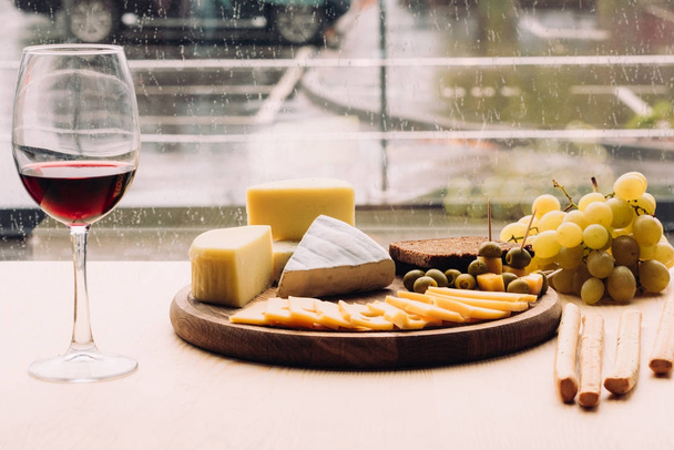 Egy pohár vörösbor és sajt - Fotó, kép
