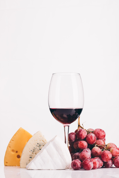 cheese, glass of red wine and grapes - Photo, Image