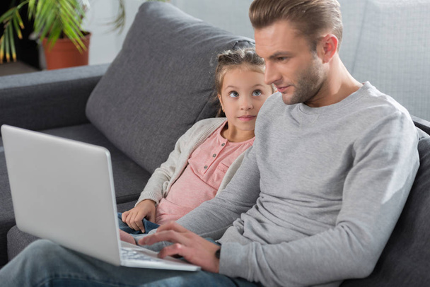 Отец и дочь смотрят на ноутбук
 - Фото, изображение