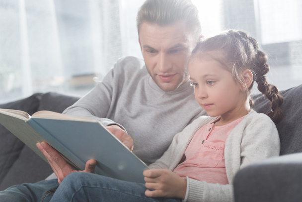 Father teaching daughter read at home - Photo, Image
