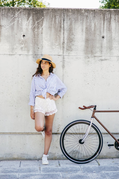 Девушка в шляпе рядом с велосипедом
 - Фото, изображение