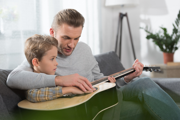 Vater lehrt Sohn Gitarre spielen - Foto, Bild