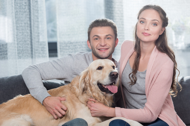 couple on couch petting dog - Photo, Image