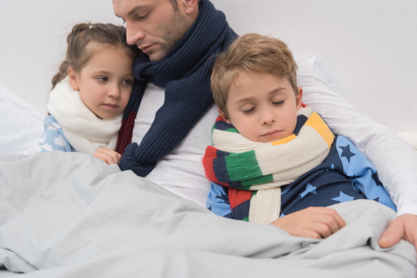Père malade avec fils et fille au lit
  - Photo, image