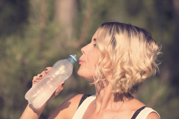 Dívka pije vodu v letní park - Fotografie, Obrázek