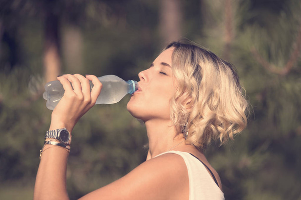 Ragazza beve acqua in un parco estivo
 - Foto, immagini