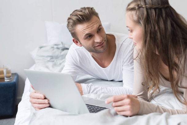 Couple lying with laptop - Foto, Imagen