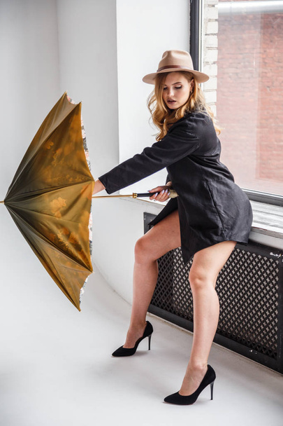 model in black shirt and hat with umbrella  - Photo, Image