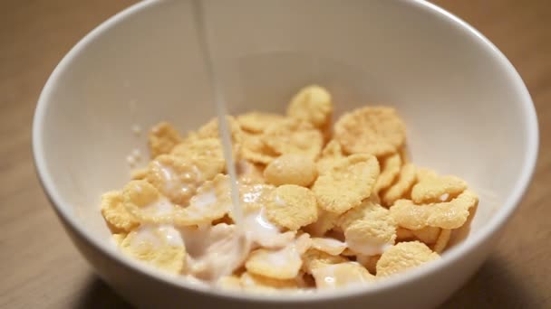 Pouring milk in bowl with corn flakes - Footage, Video