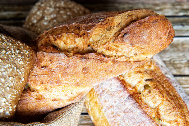 frisch gebackenes hausgemachtes Brot auf rustikalem Holzboden. - Foto, Bild