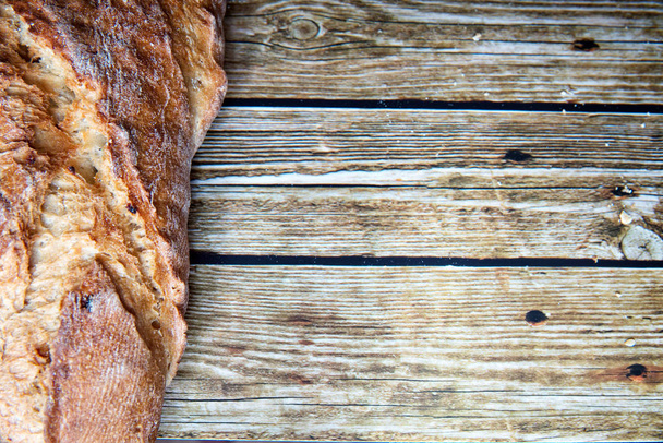 Freshly baked homemade bread on rustic wooden background. - Foto, Imagen