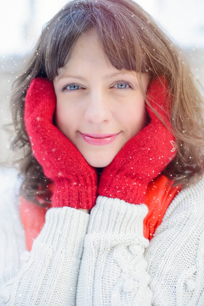 Vendita di Natale. Bella donna sorpresa in guanti rossi e maglione bianco sfondo invernale con neve, emozioni. Divertente ritratto da donna risata. Anno nuovo vendite
 - Foto, immagini