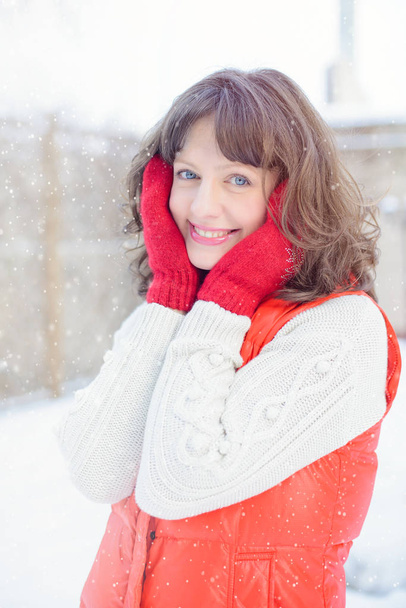 Venta de Navidad. Hermosa mujer sorprendida en manoplas rojas y suéter blanco fondo de invierno con nieve, emociones. Gracioso retrato de mujer riendo. Ventas de año nuevo
 - Foto, Imagen