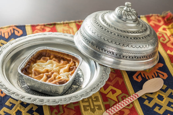 Budino di riso (muhallebi) in piatto vintage con moquette e cucchiaio
 - Foto, immagini