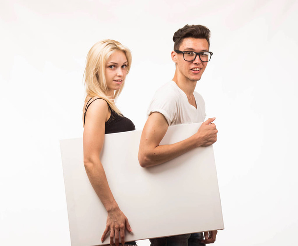 Young confident couple showing presentation pointing placard. - Fotó, kép