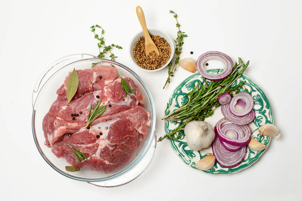 Raw meat in a transparent pot with herbs and spices - Foto, Bild