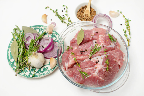  Raw pork meat with herbs and spices on white background - Foto, Bild