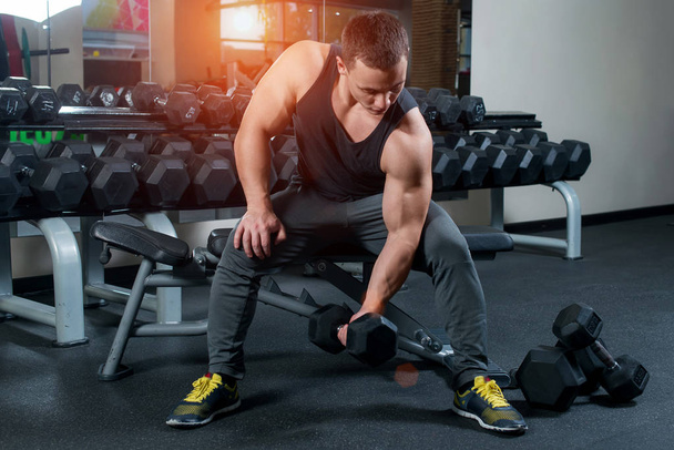 Bodybuilder in gym exercising with dumbbells. Sports concept.  - Fotó, kép
