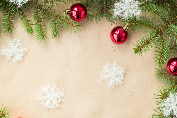 Bordure de Noël festive avec boules rouges sur branches de sapin et flocons de neige sur fond beige rustique
 - Photo, image