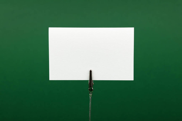Blank white paper sign over green background - Valokuva, kuva