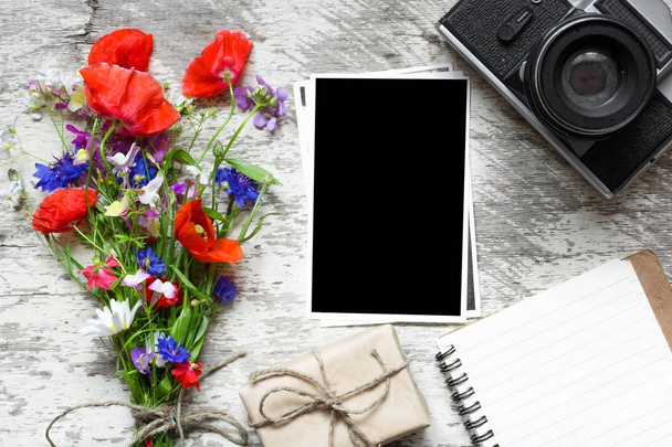 cámara retro vintage con marco de fotos en blanco y ramo de flores silvestres con cuaderno forrado y caja de regalo
 - Foto, Imagen