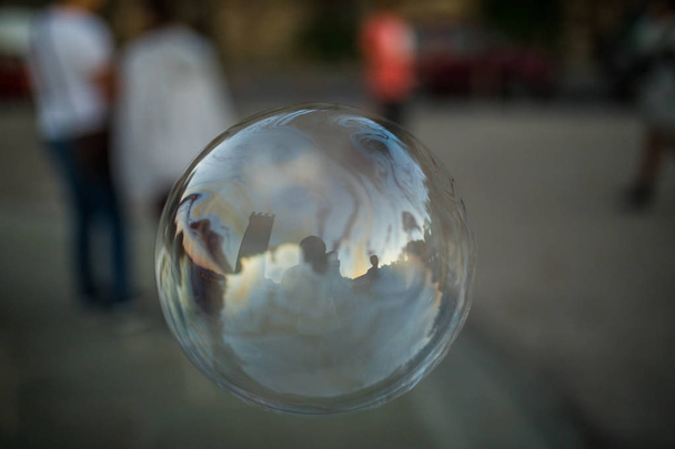 Coloridas burbujas flotan por el aire en un entorno urbano
. - Foto, imagen