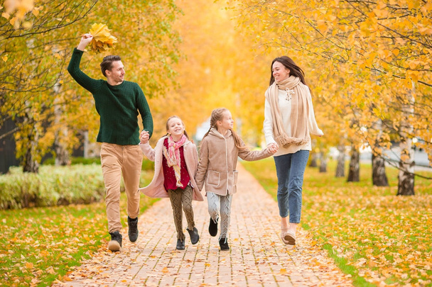 Ομορφη ευτυχισμένη οικογένεια από τις τέσσερις φθινοπωρινή ημέρα σε εξωτερικούς χώρους - Φωτογραφία, εικόνα