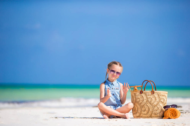 Чарівна маленька дівчинка з пляжною сумкою та рушником під час літніх канікул
 - Фото, зображення