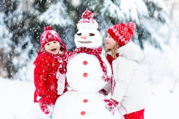 Kids building snowman. Children in snow. Winter fun. - Valokuva, kuva
