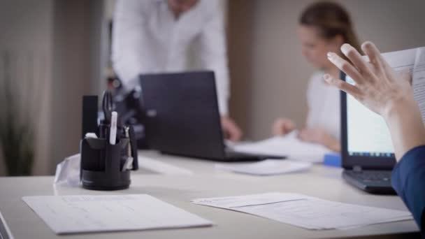 Colleagues at workspace busy with paperwork and working with devices - Imágenes, Vídeo