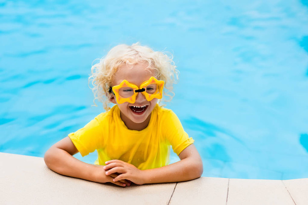 Το παιδί με τα γυαλιά στην πισίνα. Τα παιδιά κολυμπούν. - Φωτογραφία, εικόνα