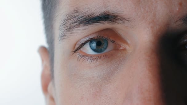 κοντινό πλάνο του μια θλιβερή επανδρώνει μπλε μάτι σε απομονωμένες άσπρο φόντο - Πλάνα, βίντεο