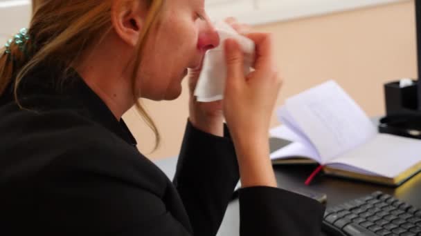 Sick business woman with flu blowing nose in tissue. in the office. 4k, slow motion - Πλάνα, βίντεο