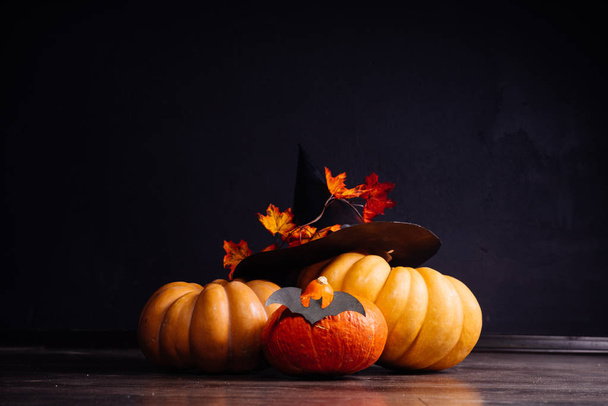a composition for decorating a house for halloween, orange pumpkins, a big black witch hat - Fotó, kép