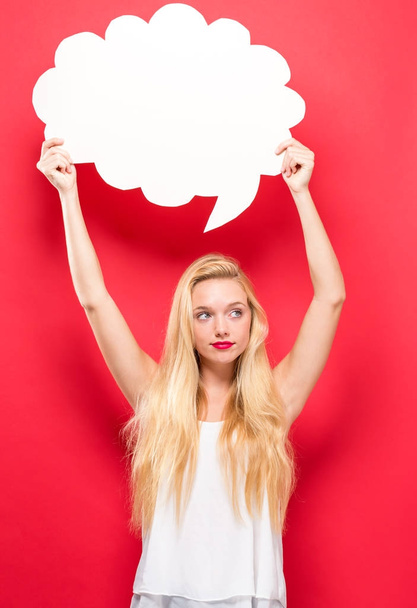Young woman holding a speech bubble  - Foto, afbeelding