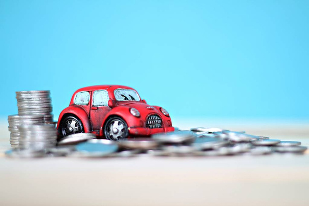 Modelo de coche en miniatura y pila de monedas en la mesa de escritorio
 - Foto, imagen