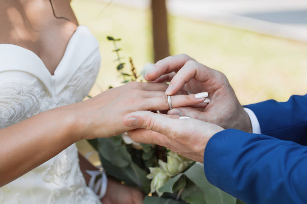 O noivo coloca o anel na mão da noiva. Fecho da foto
 - Foto, Imagem