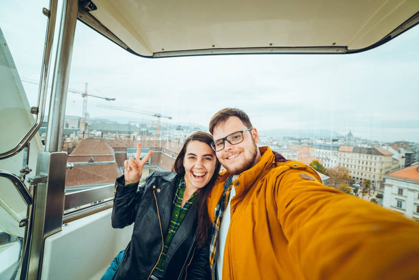 man with woman at ferris wheel taking a selfie - Photo, image
