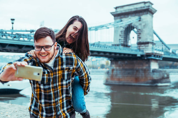 lovely cople taking selfie bridge on background - Photo, Image
