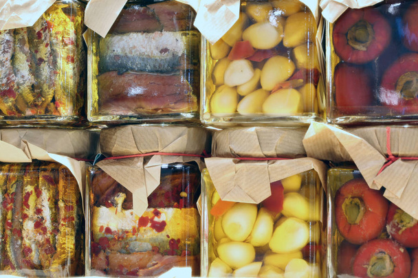 jarros de produtos italianos conservados em óleo com alho e pimenta
 - Foto, Imagem