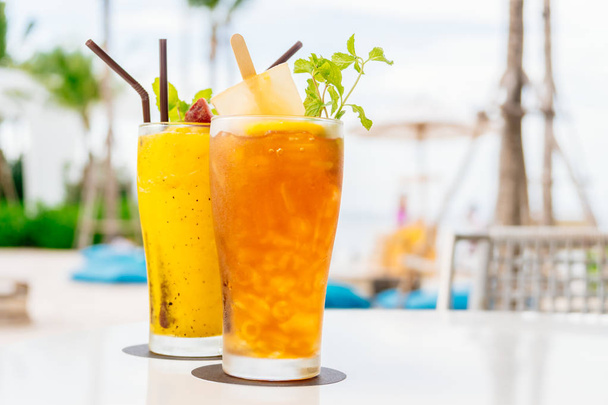 Крижані коктейлі п'ють скло з пляжем і морем
 - Фото, зображення