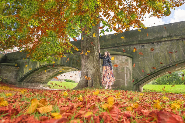 Κορίτσι κάτω από ένα δέντρο με φύλλα που πέφτουν - Φωτογραφία, εικόνα