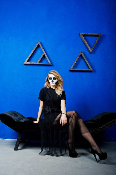 Halloween skull make up girl wear in black against blue wall at  - Foto, Imagen