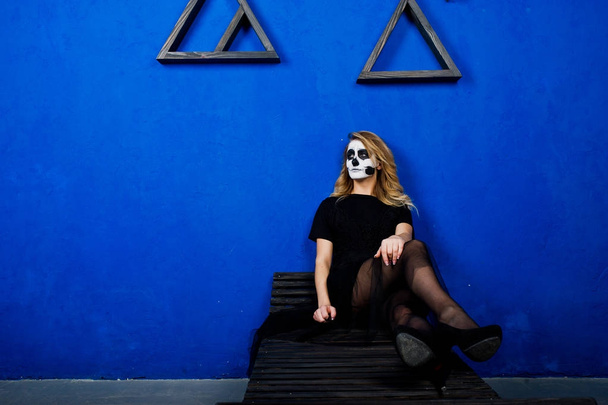 Halloween skull make up girl wear in black against blue wall at  - Foto, Imagem